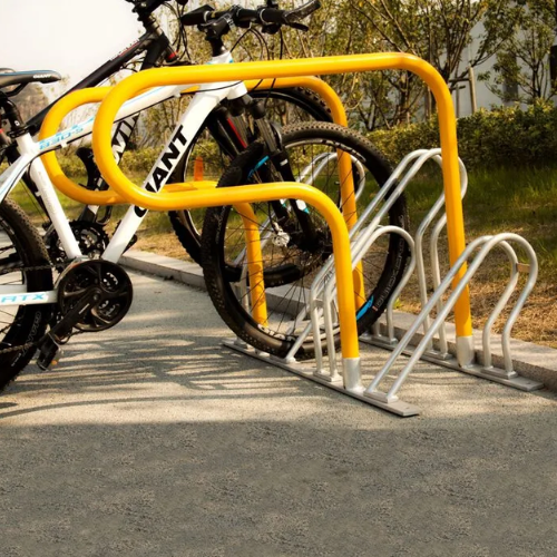 Yellow bike rack with bicycles parked on a concrete surface.