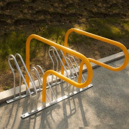 Bicycle rack with yellow and silver design on a concrete surface.